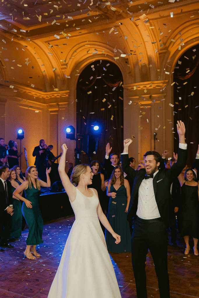 Lively reception dance floor with live band, confetti pop, and uplighting in a Chicago ballroom