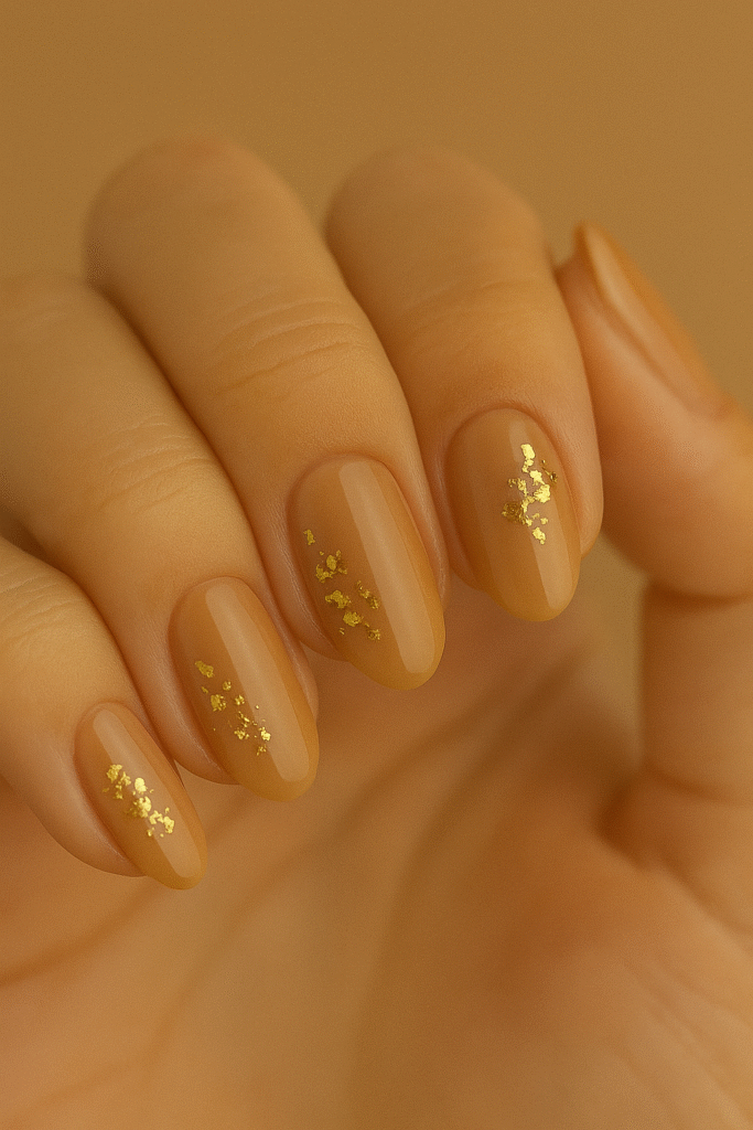 Caramel latte nude nails with gold foil clusters—fall nail inspo for warm skin tones in the USA.