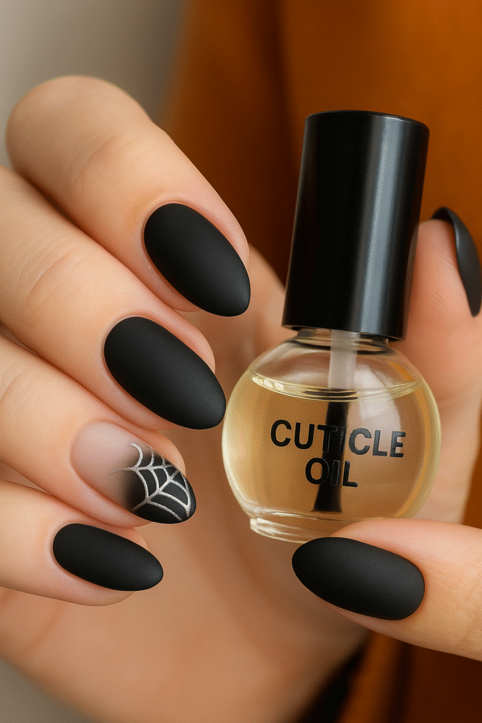 Cuticle oil bottle next to a Halloween manicure, emphasizing nail health and safe polish removal
